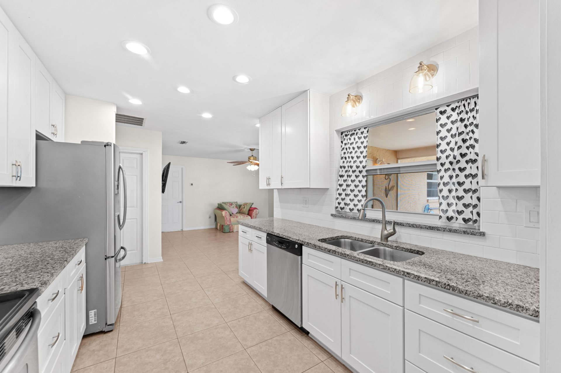 Kitchen with double sink, dishwasher and pass-through window to family room