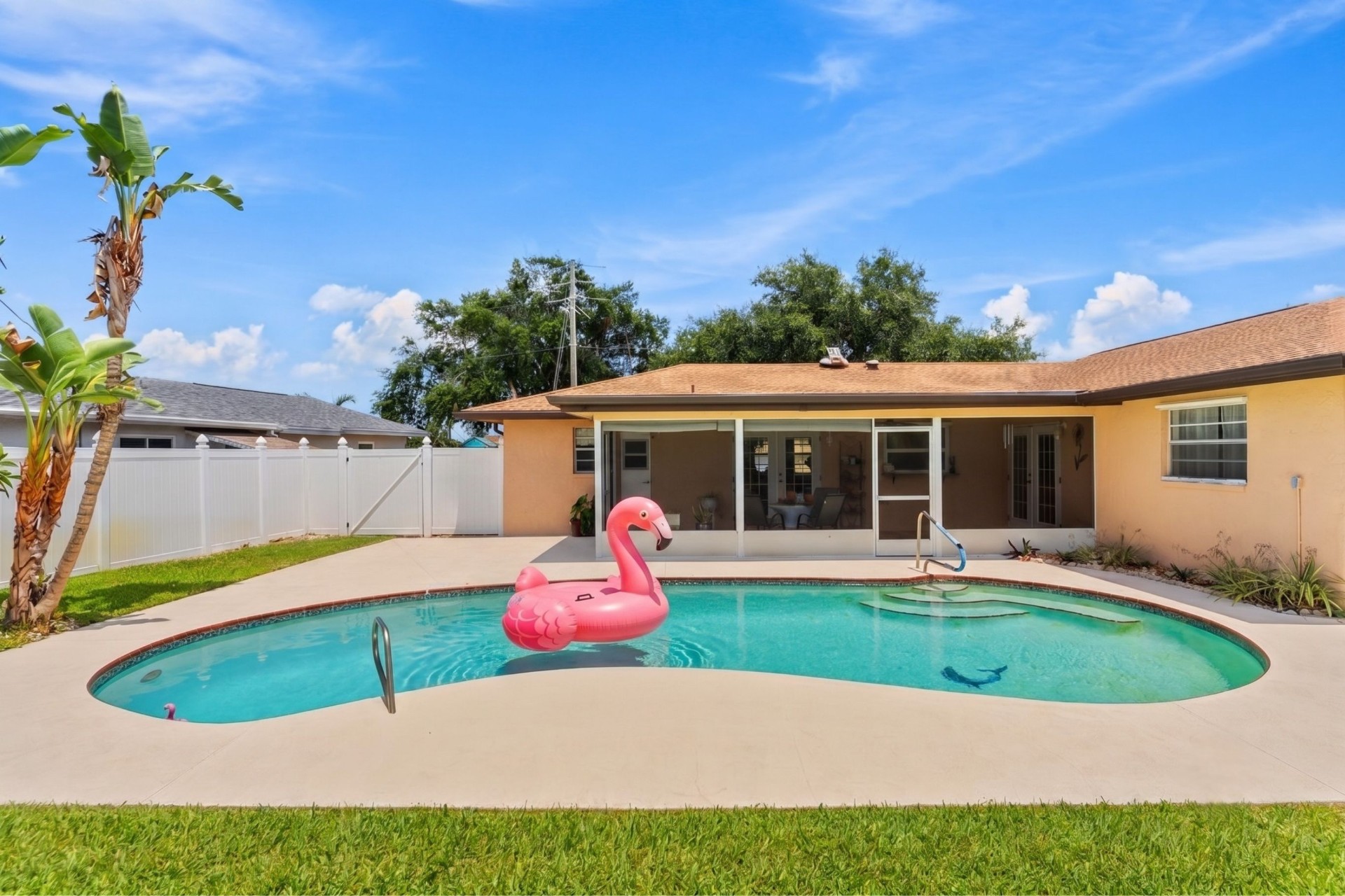 Backyard with in-ground pool, screened lanai and privacy fence