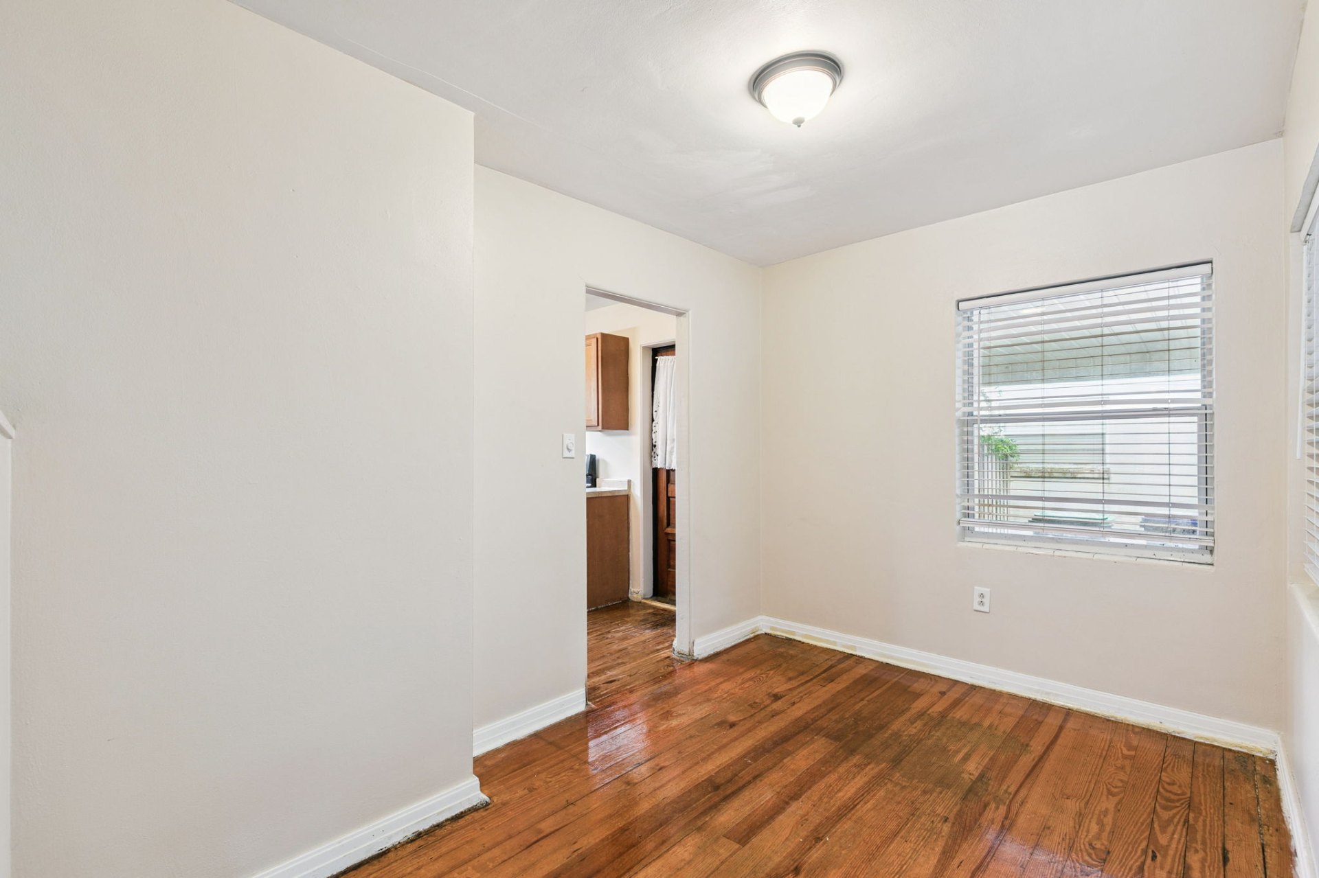Cozy dining area off the kitchen with rich refinished hardwoods and fresh neutral paint