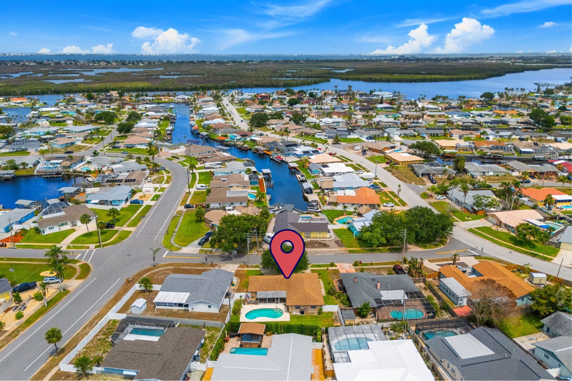 Aerial view of the home and surrounding canal-front neighborhood