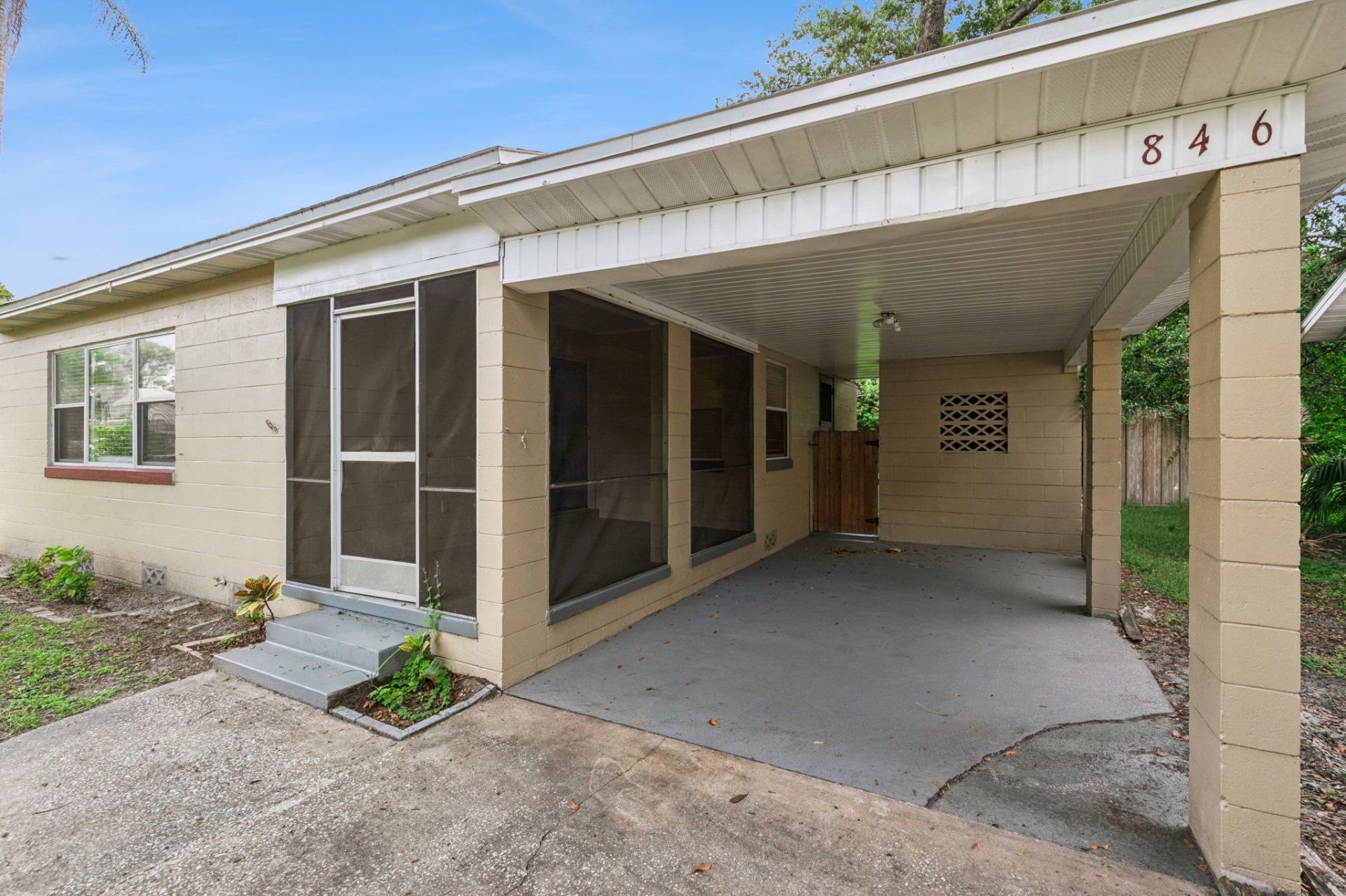 Covered carport and screened front porch of 846 Driver Ave, a 1953 concrete-block cottage in Winter Park