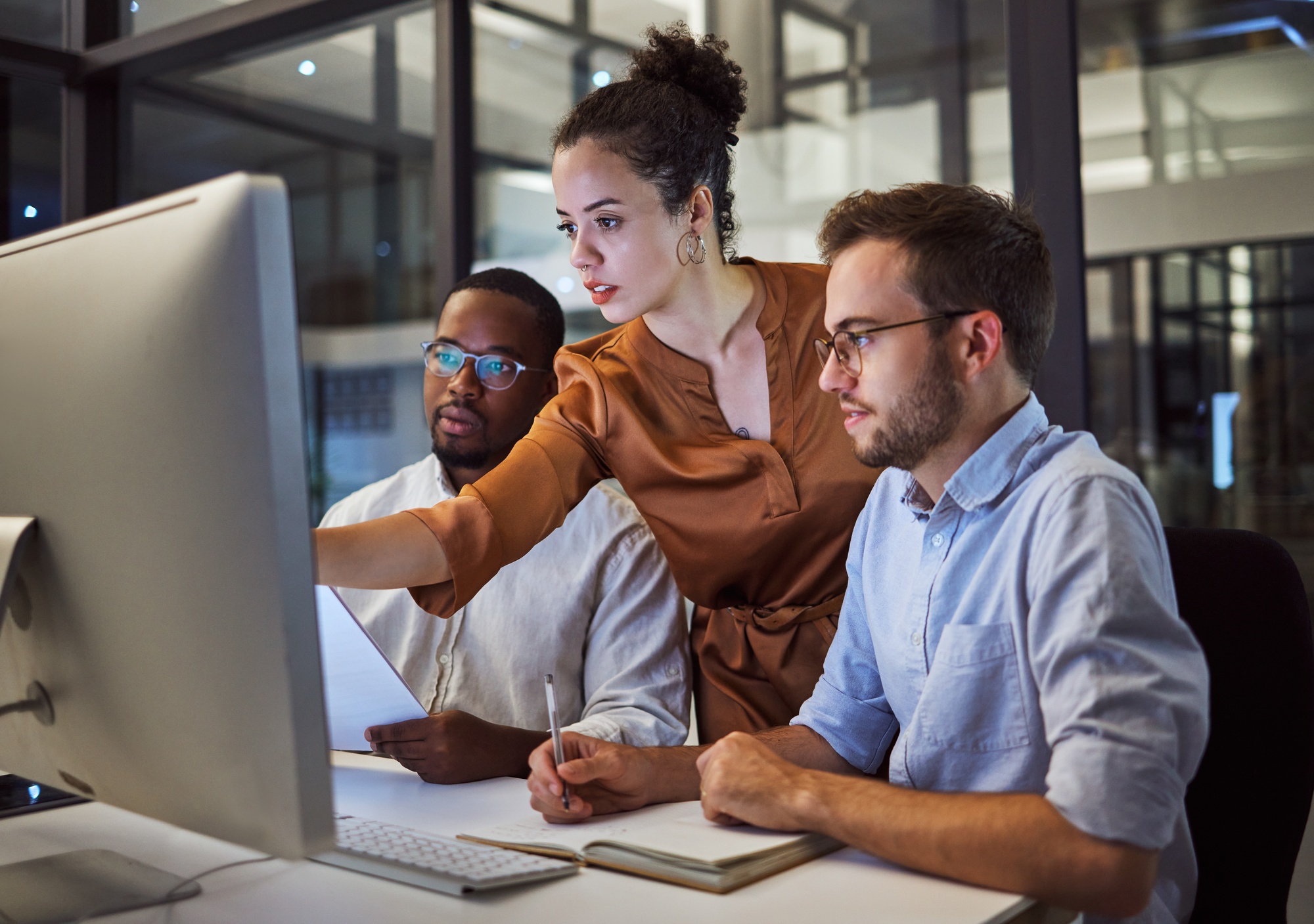 Two colleagues reviewing work on a computer in an office