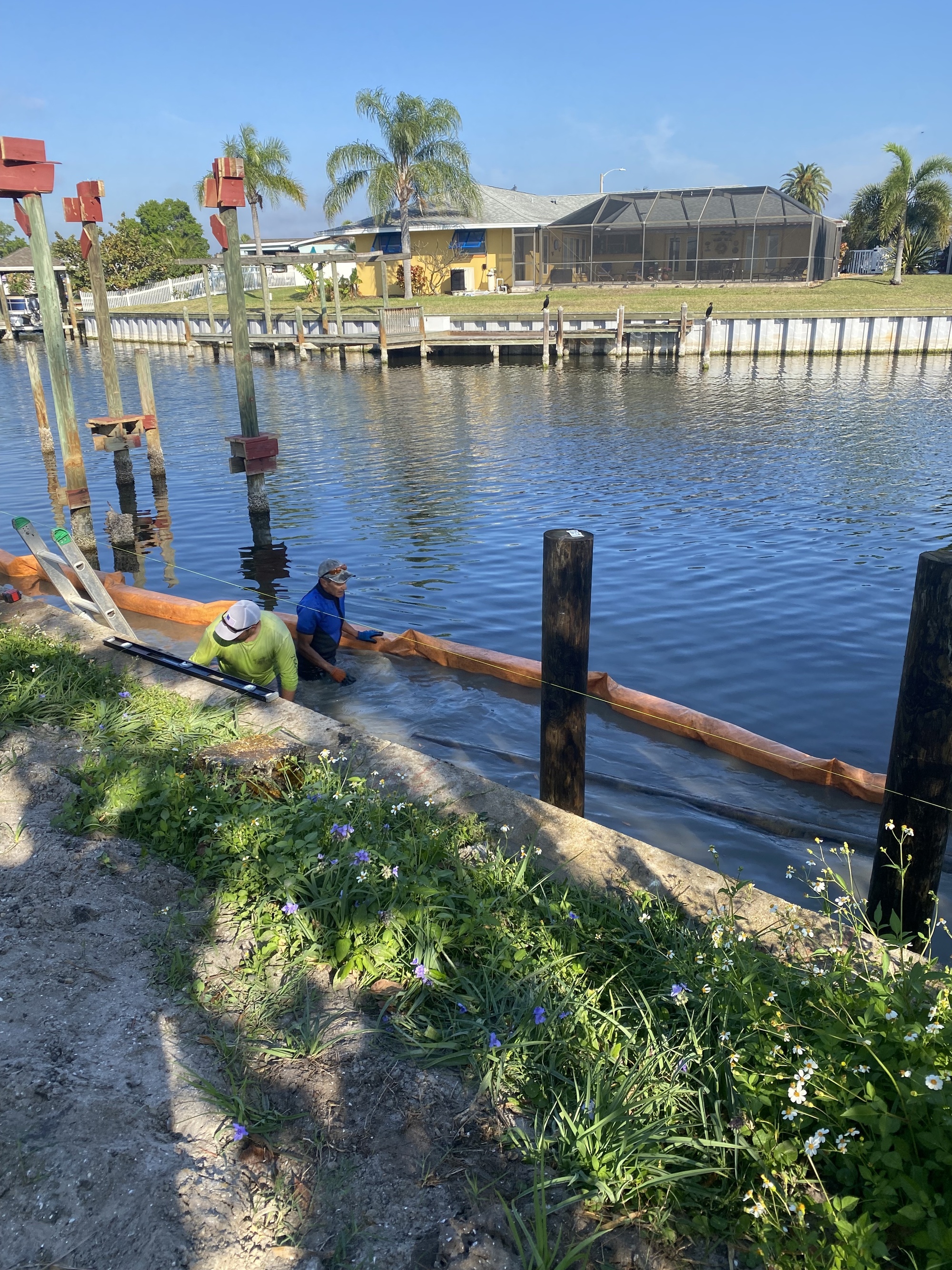 Marine contractors driving panels for a new seawall at a Diana Shores home