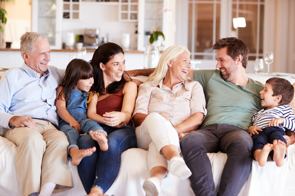 Three generations of a family gathered together outside a home